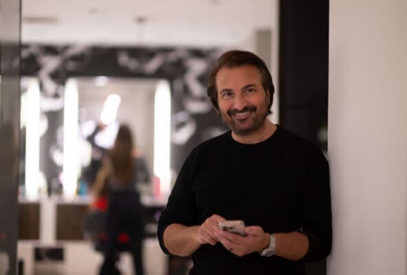 A salon owner using mobile phone for 2-way SMS messaging with client